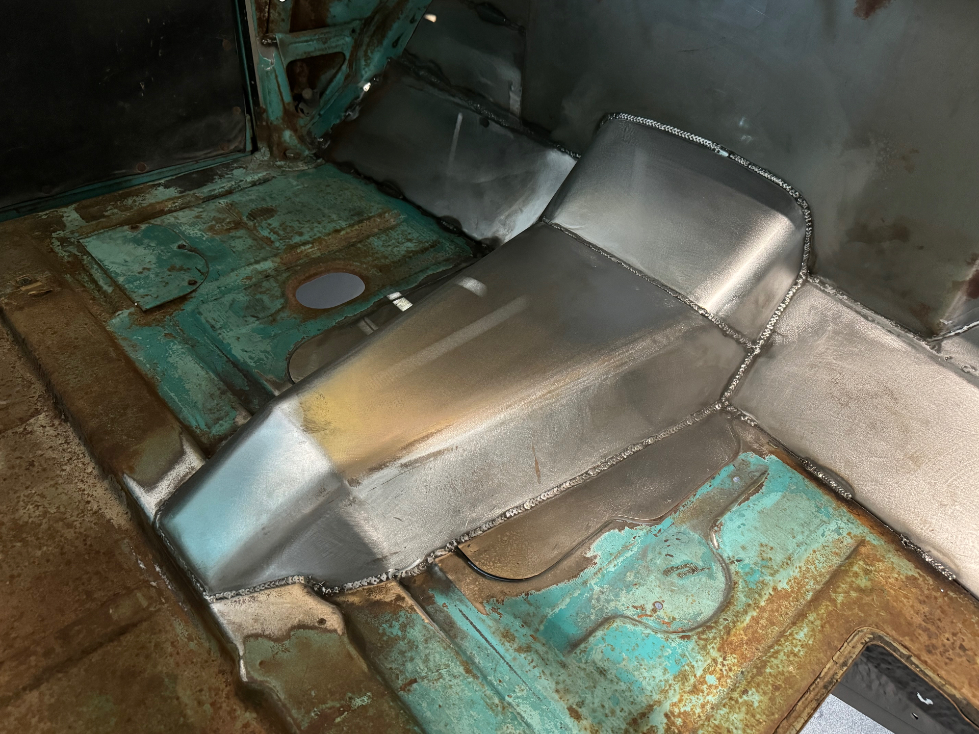 Passenger side — welds dressed, contours flowing into the stock floor pan.