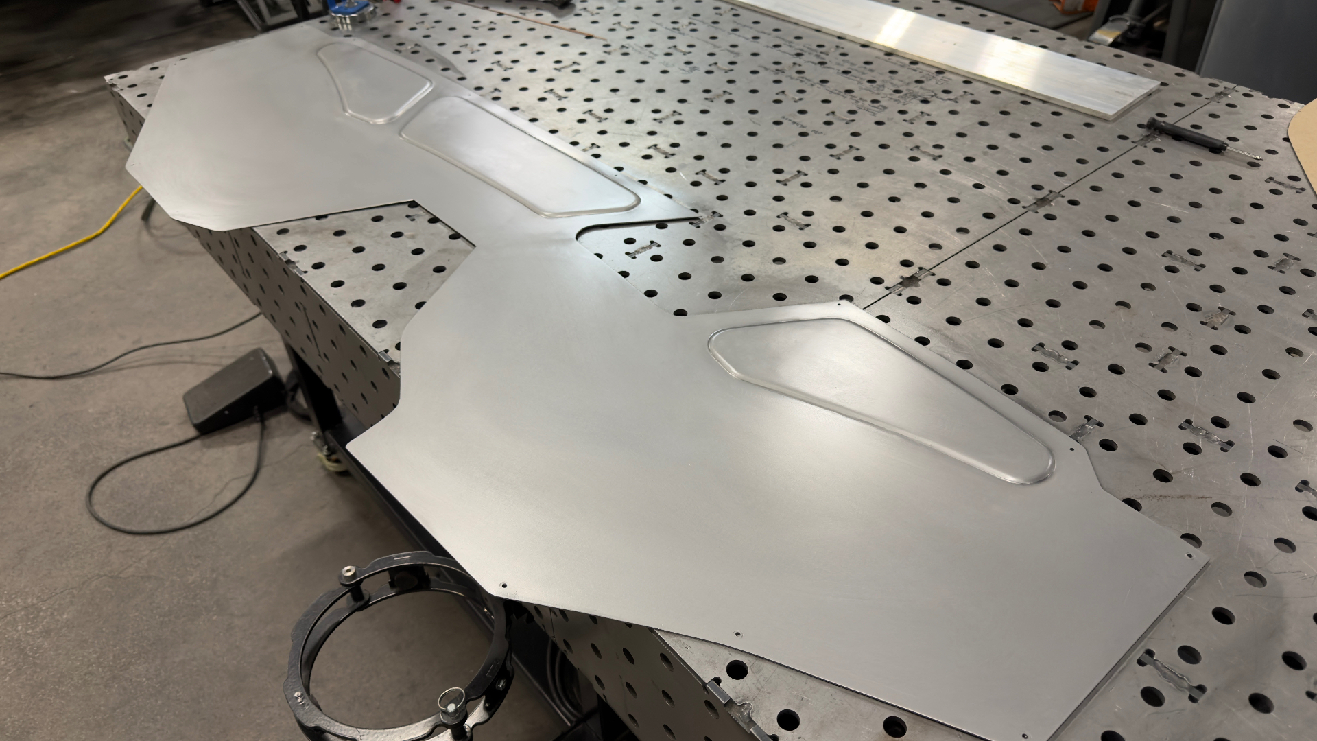 Hand-formed aluminum firewall panel with recessed pockets, off the English wheel.