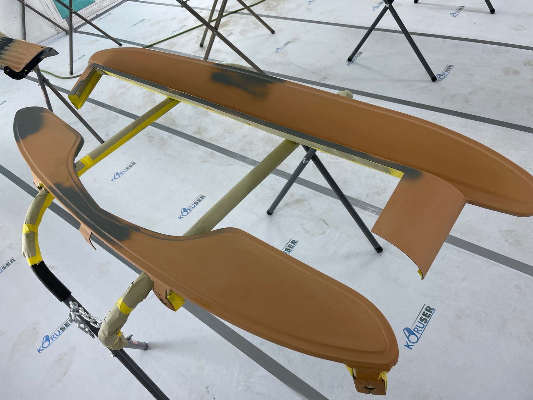 Guide-coat sanding on the running board — dark shadows show the low spots to chase.