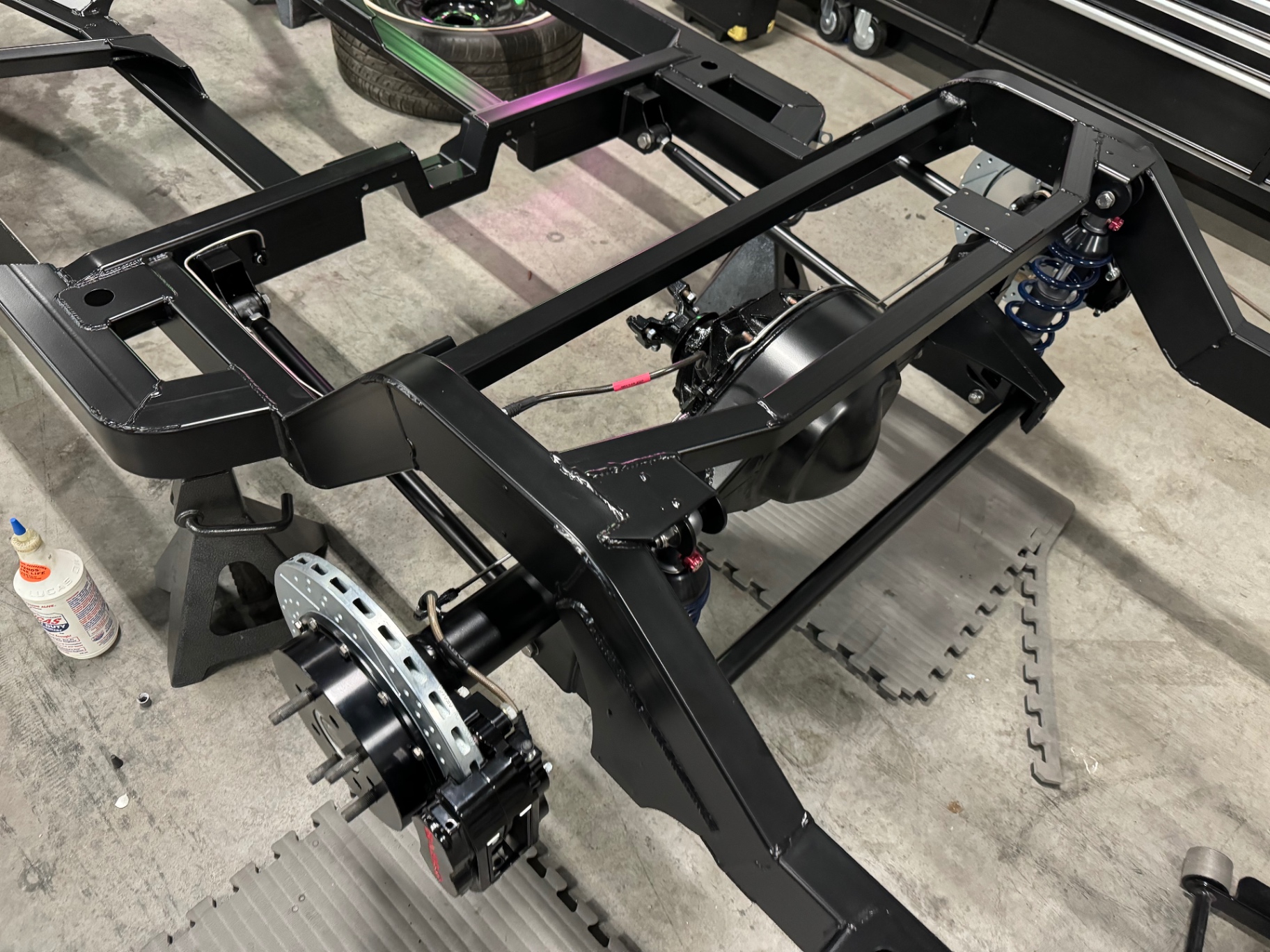 Rear chassis assembly — parallel 4-bar, Fox coilovers, and drilled rotors.