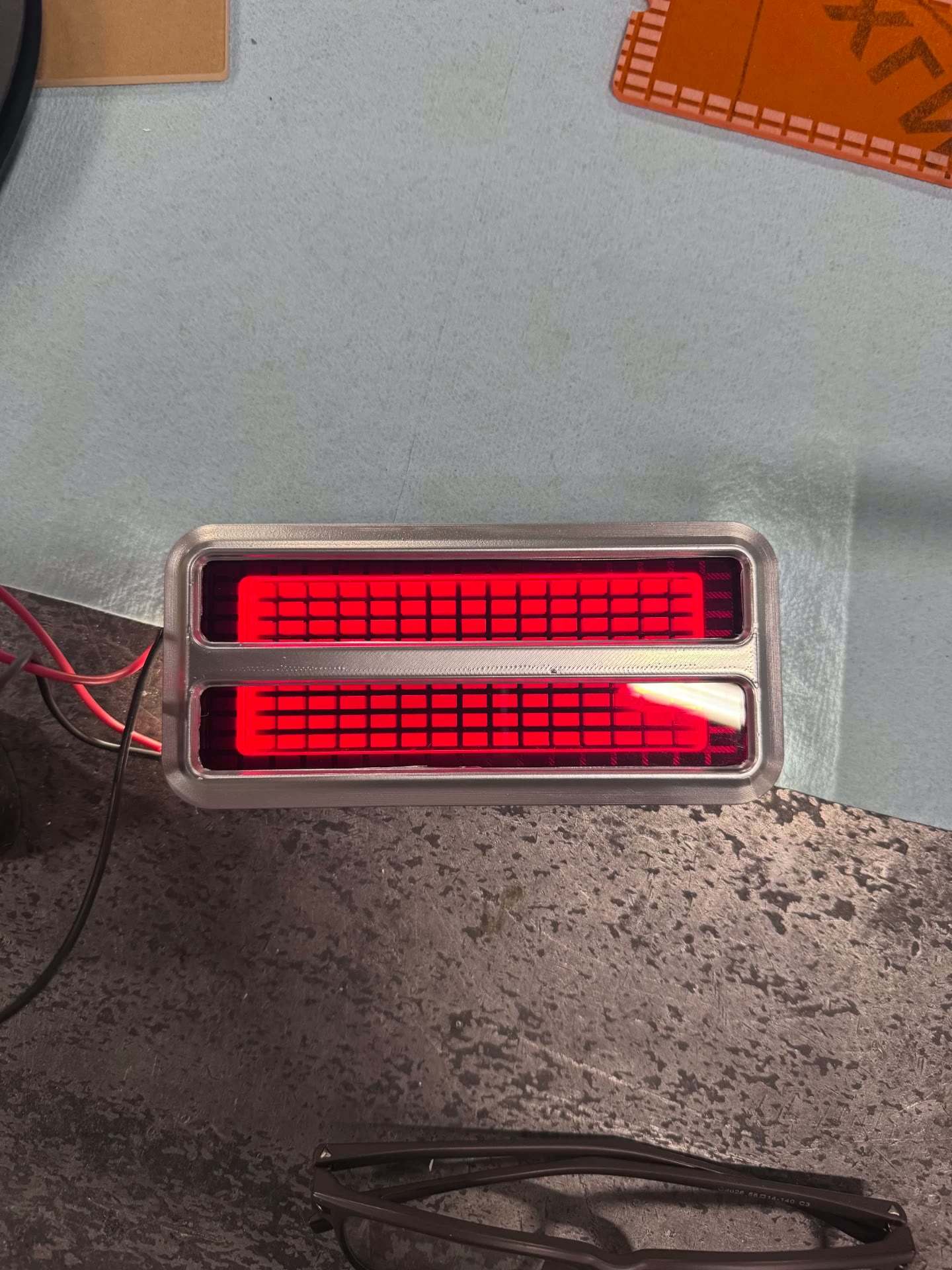 Edge-lit engraved lens lit up in red — no bulb or socket behind it.