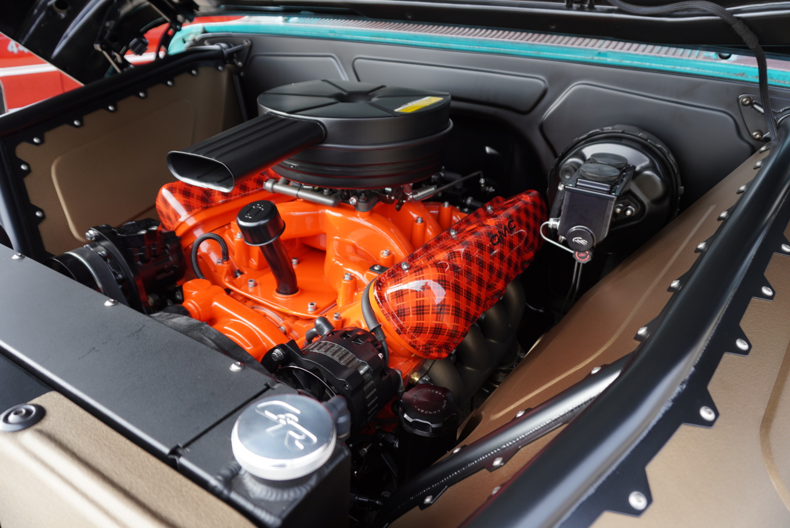 Engine bay — plaid valve covers and orange GMC powerplant detail.