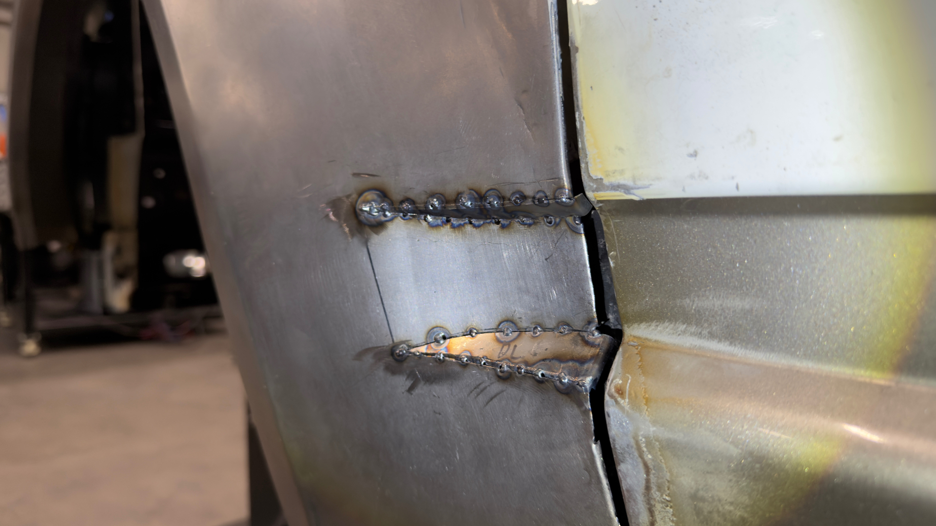 Quarter panel stitch welds — tacked, cooled, and blended in stages to keep the metal flat.
