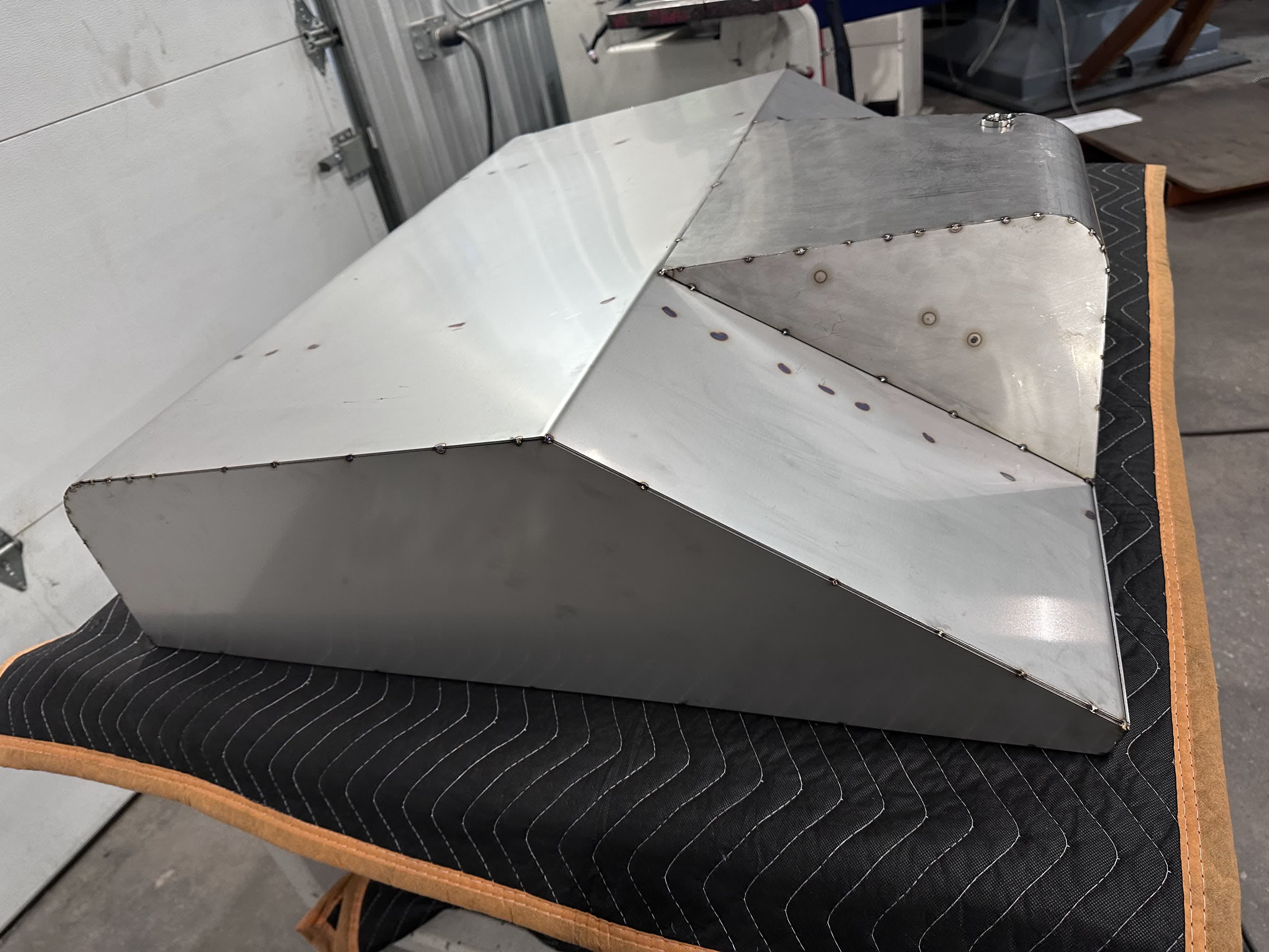 Fully clecoed stainless tank on the bench — every seam pinned before TIG welding.