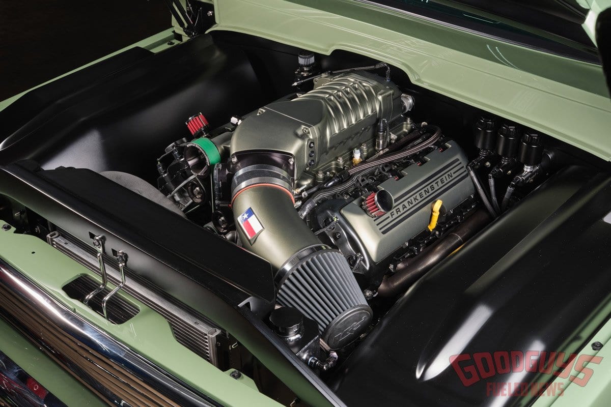 Custom firewall and smoothed engine bay wrapping the supercharged Coyote.