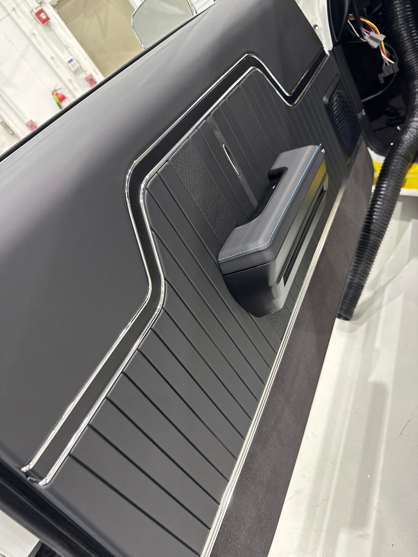 Door panel installed — 3D-printed structure, Alcantara insert, chrome trim, blue stitching.