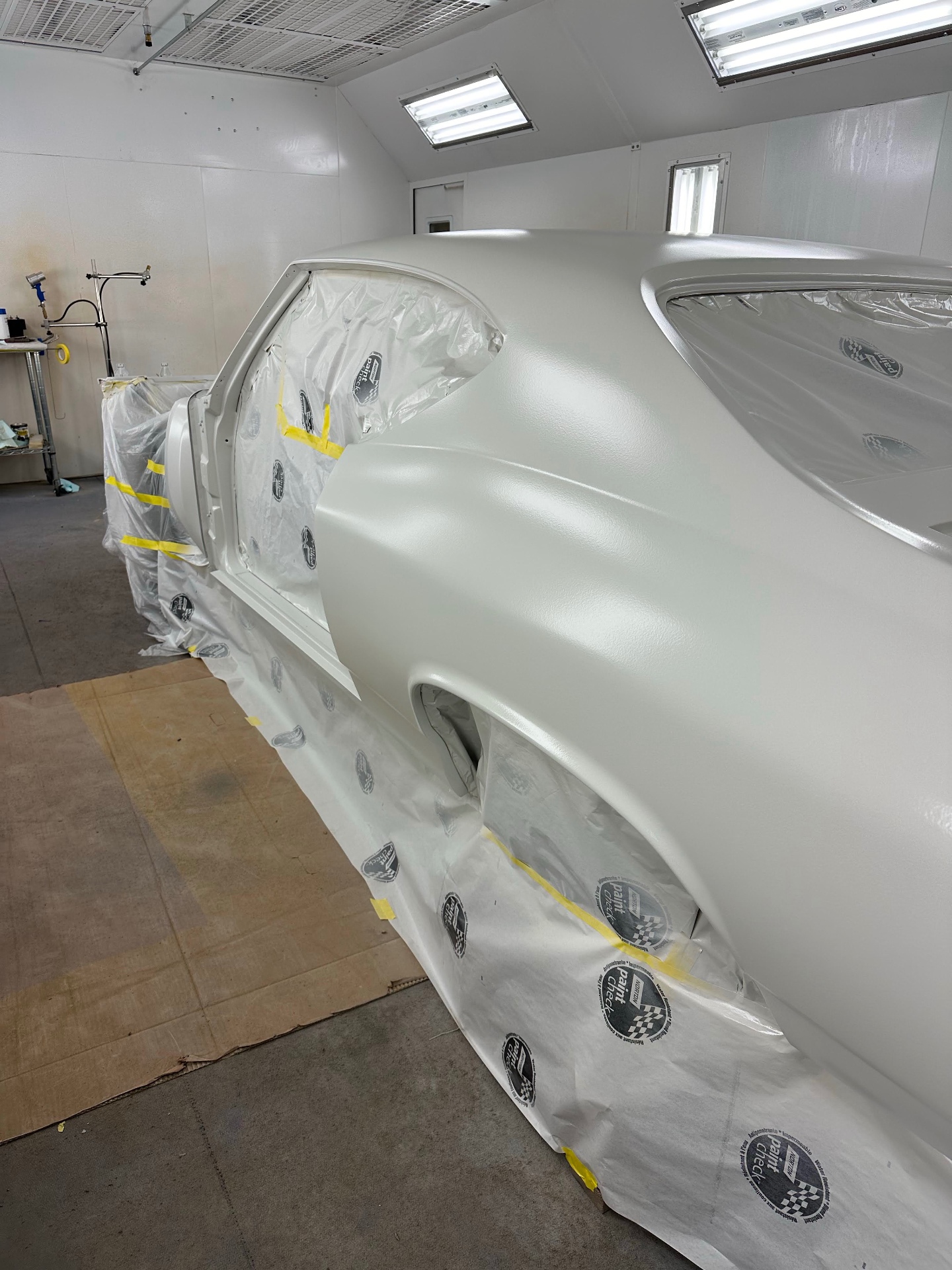Driver-side quarter with pearl white base fully laid down.
