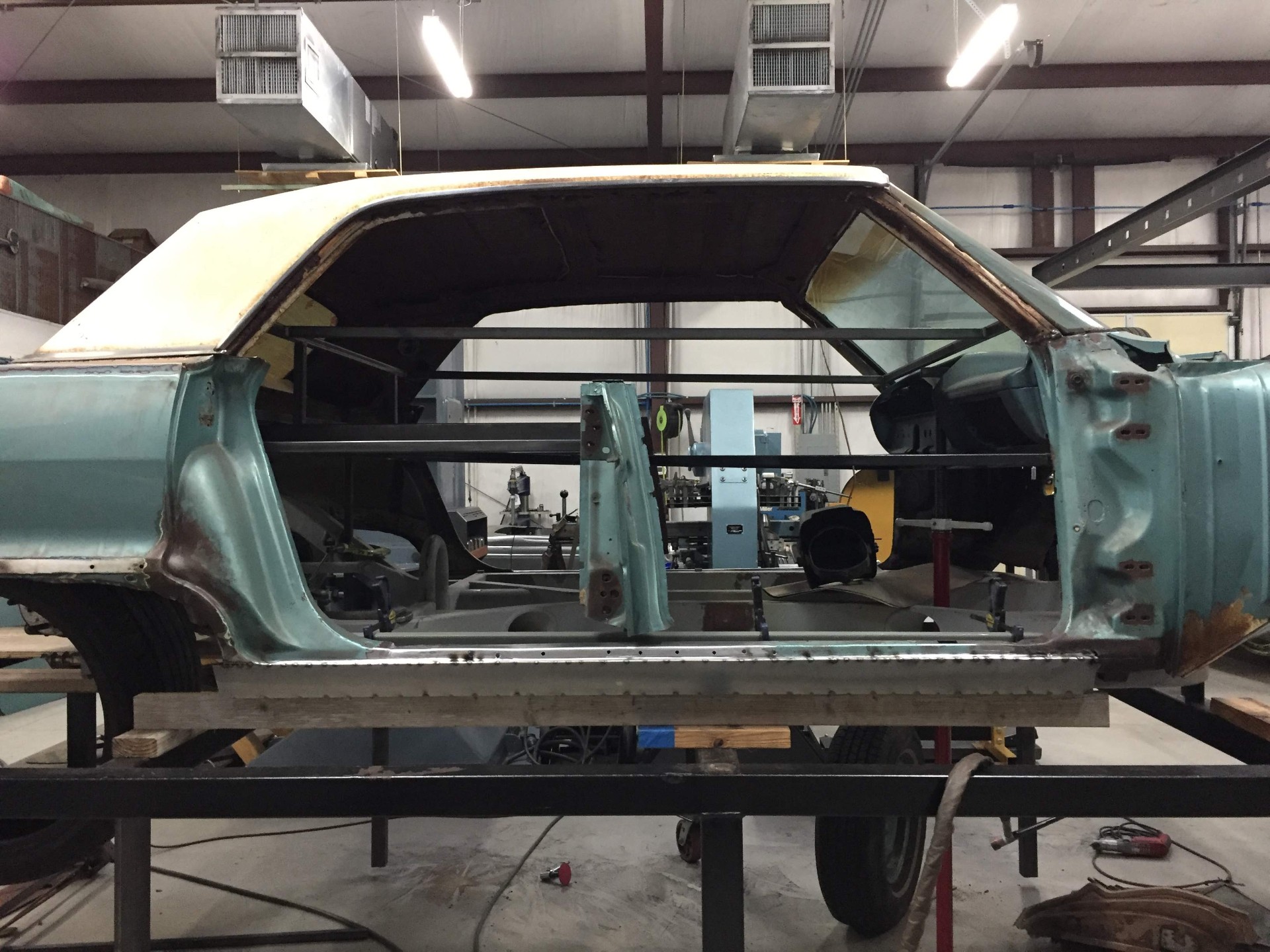 Two-door roof clamped in place on the shell — the donor hardtop being fitted to the four-door body before final welding.