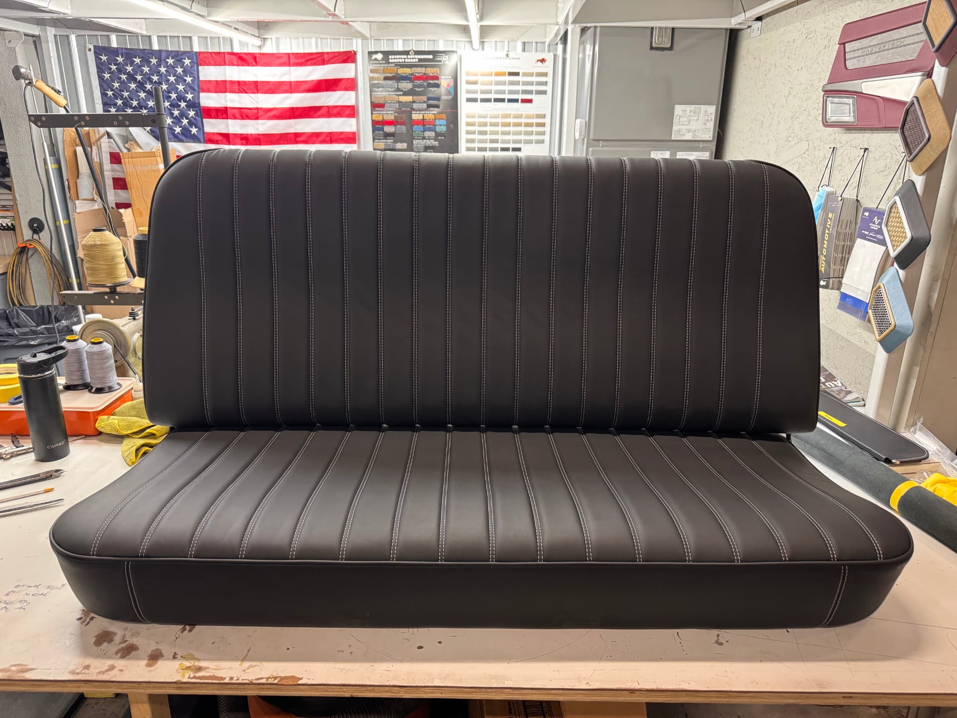 The finished bench: black leather, pleated inserts, contrast stitching.