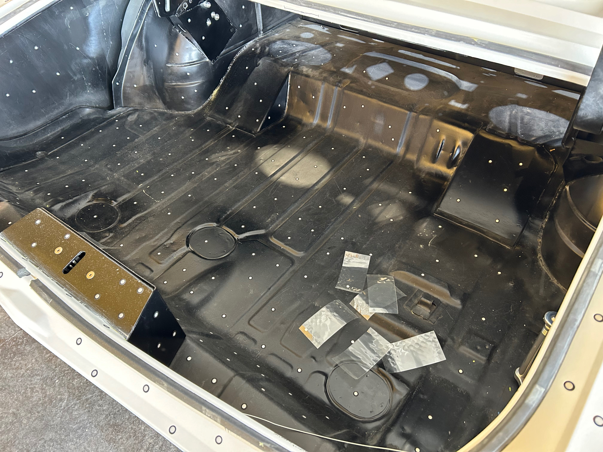 Rear interior floor and wheel tubs coated black — targets set for full-body 3D scan.
