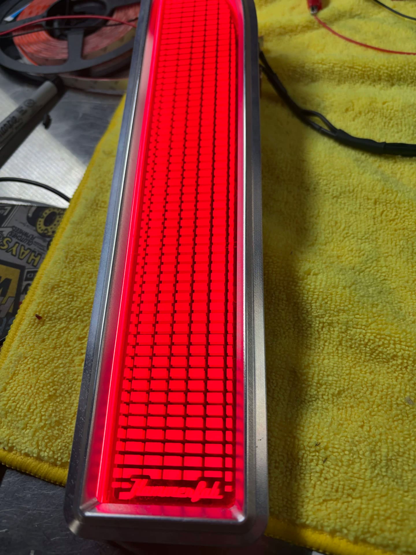 Full-length engraved lens lit in red with the Hammer Fab script engraved into the face.