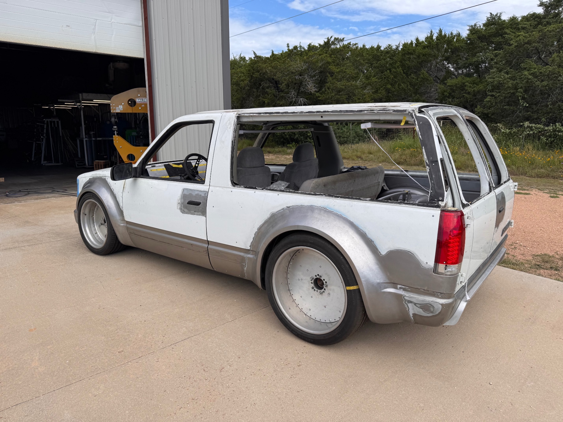 Passenger rear three-quarter showing widened quarters and rear flare.