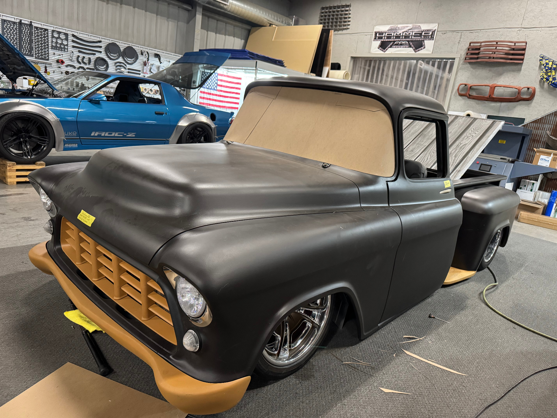 Full mockup on the shop floor next to the IROC-Z — epoxy black body, orange front clip.