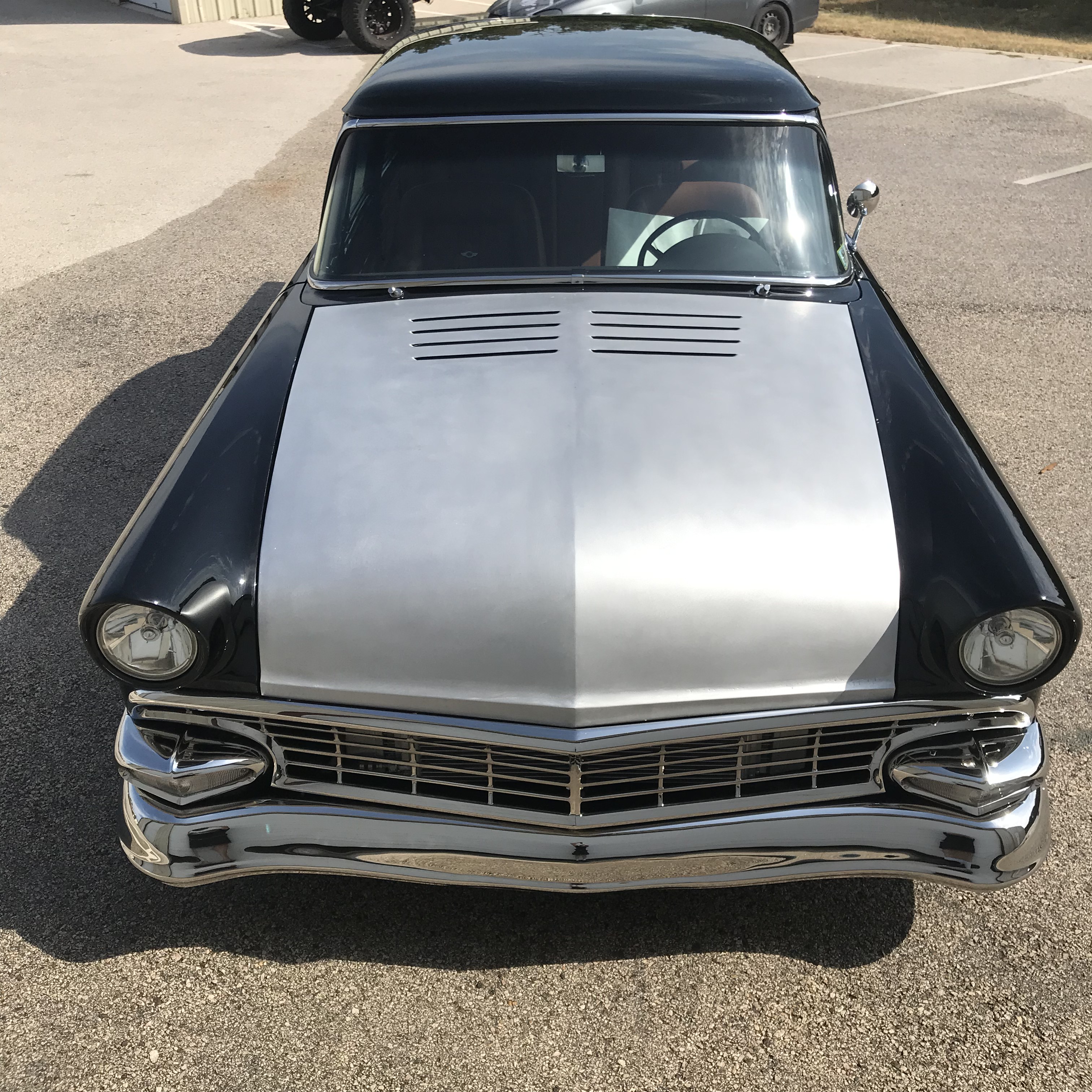 Hand-formed aluminum hood in bare metal on the finished black 1956 Ford.