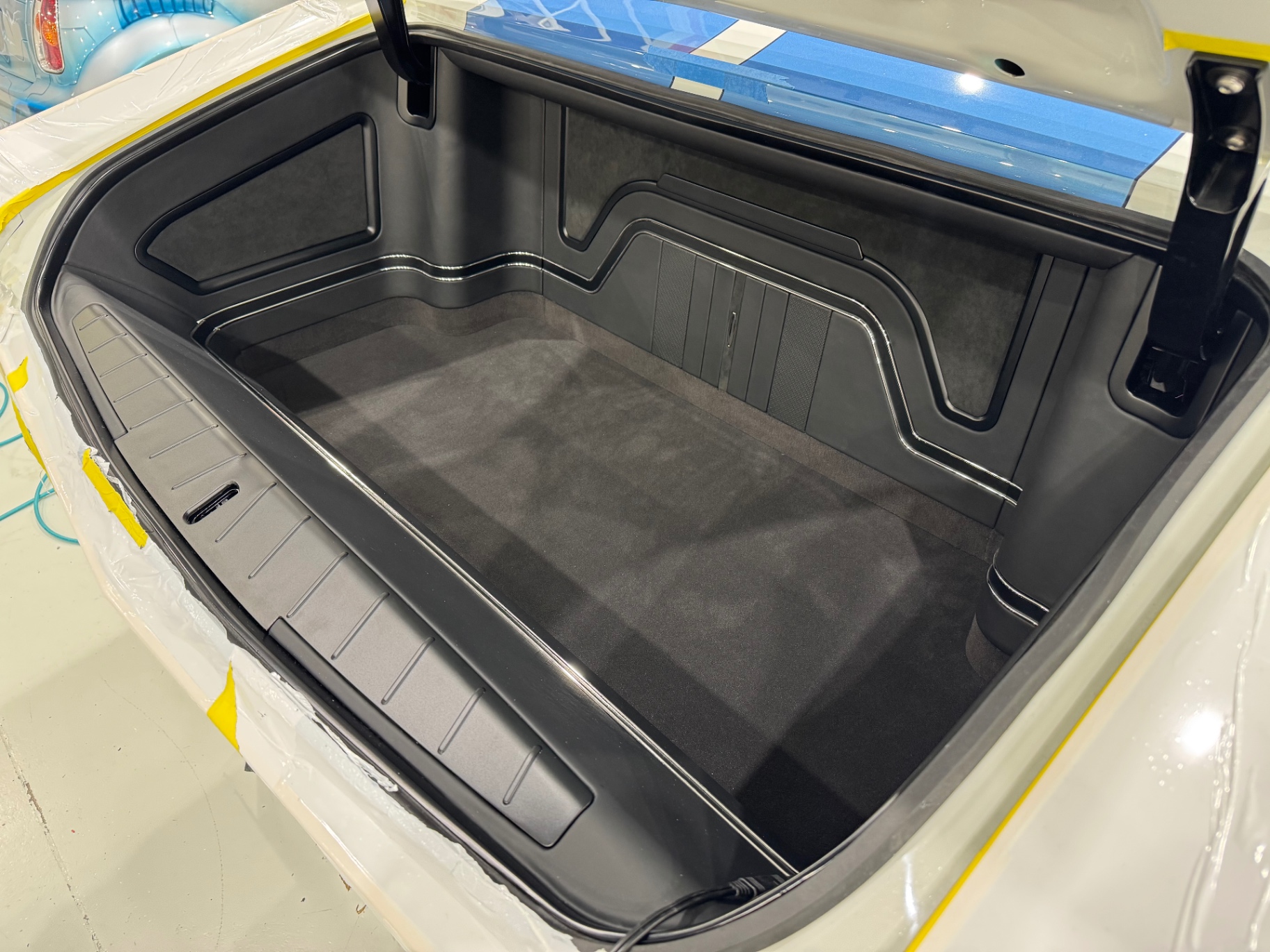 Trunk interior finished — 3D-printed panels, Alcantara-lined walls, carpeted floor.