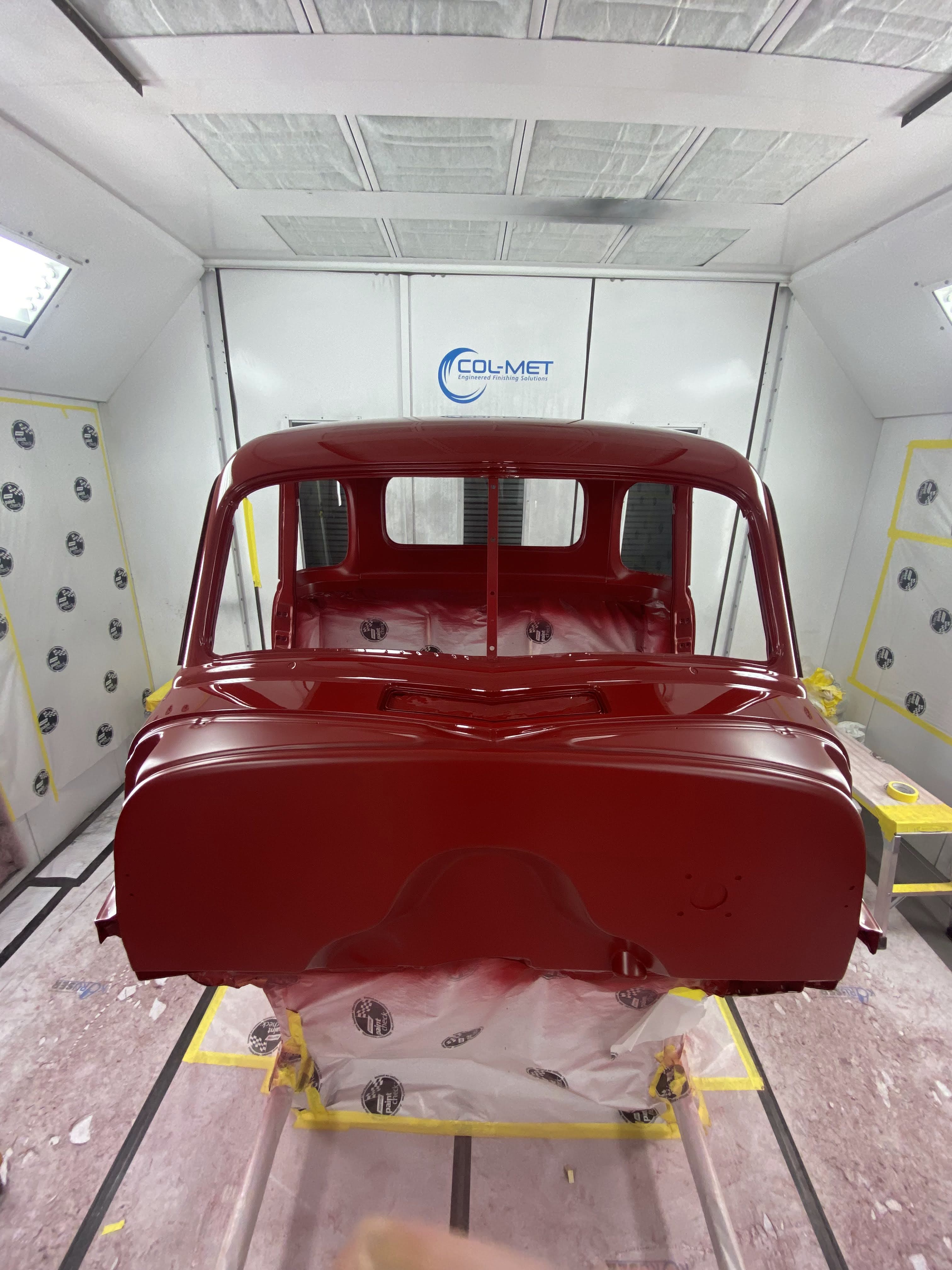 Cab head-on in Martin Bros' Col-Met booth — back of the cab, roof, and inner bed wall all sprayed in one shot.