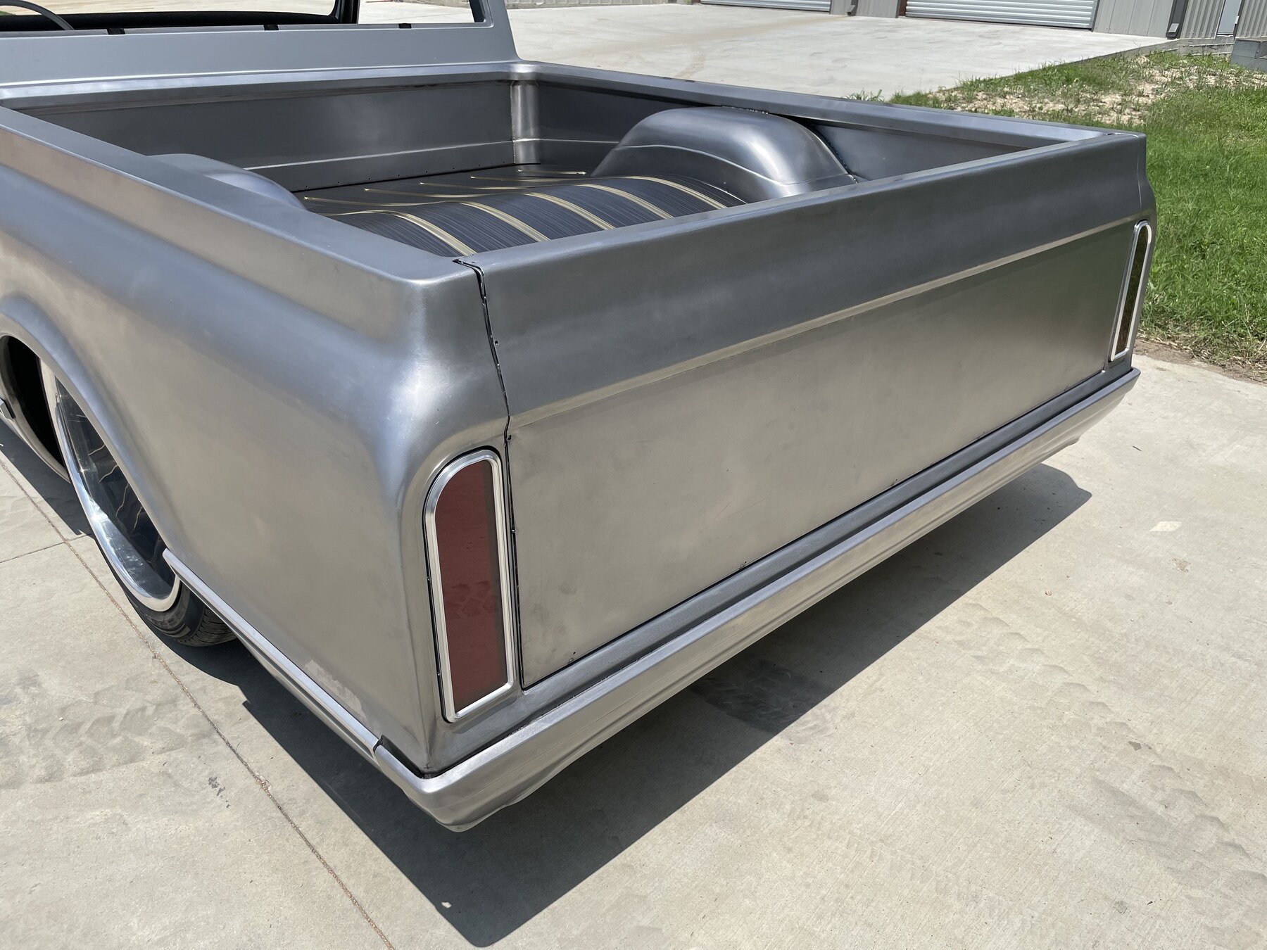 Bed rear quarter with billet tail lights and hand-built roll pan.