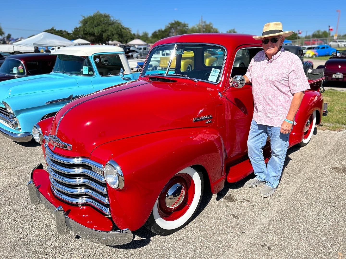 S. Comstock with the finished 3100 at its first show — red paint, chrome, wide whites, and a stance that reads right from every angle.
