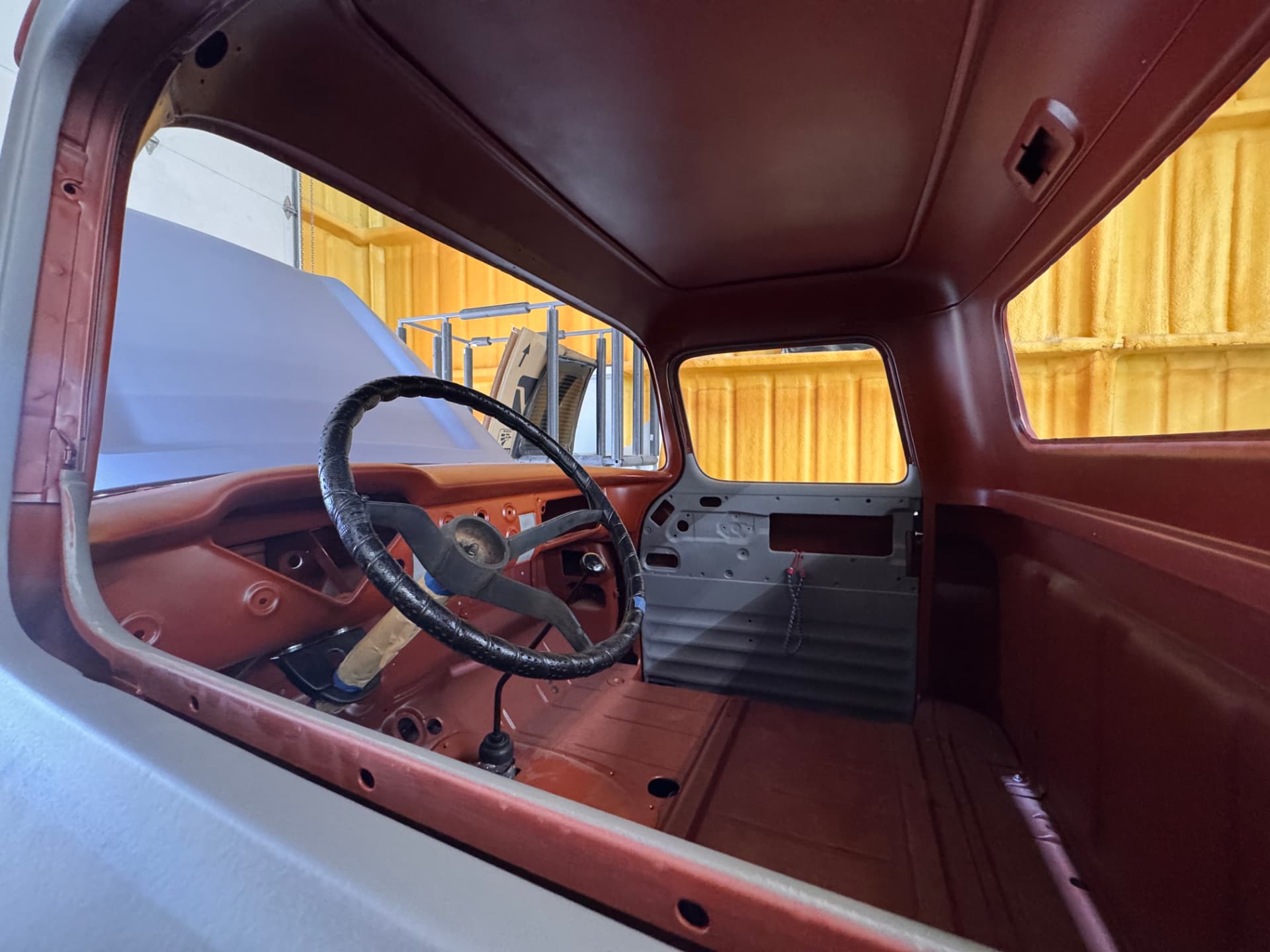 Cab interior in primer — dash, floor, and door structure straight and solid.